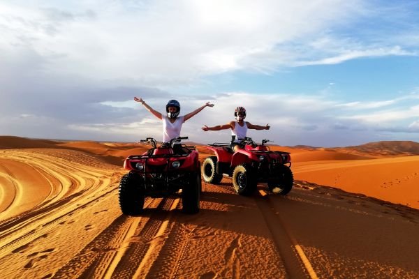Couple driving offload vehicles in Sahara Desert